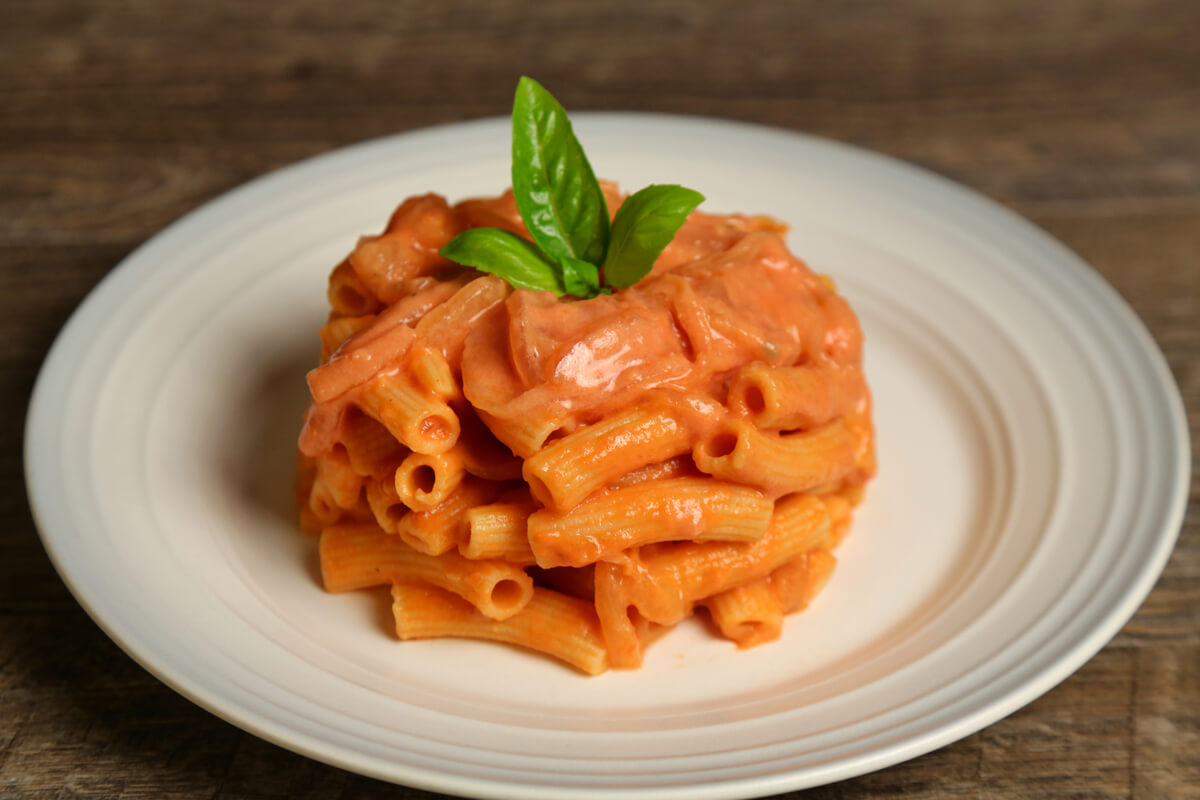 Rigatoni pasta is tubular in shape and loved for its ability to hold sauces and grated cheese on its ridges. It resembles penne but with square-cut ends and often slightly curved. Rigatoni is the favorite pasta shape in the south of Italy and Sicily. It is perfect with any sauce, from cream to the chunkiest meat sauces.